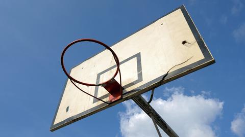 Ein beschädigter Basketballkorb auf einem Schulhof