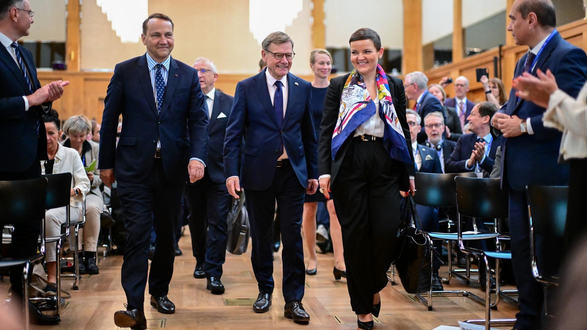 Radoslaw Sikorski (l-r), Außenminister von Polen, Johann Wadephul (CDU), Außenminister, und Marta Cienkowska, Kulturministerin von Polen, kommen während des Deutsch-Polnischen Forums im Auswärtigen Amt in den Saal. 