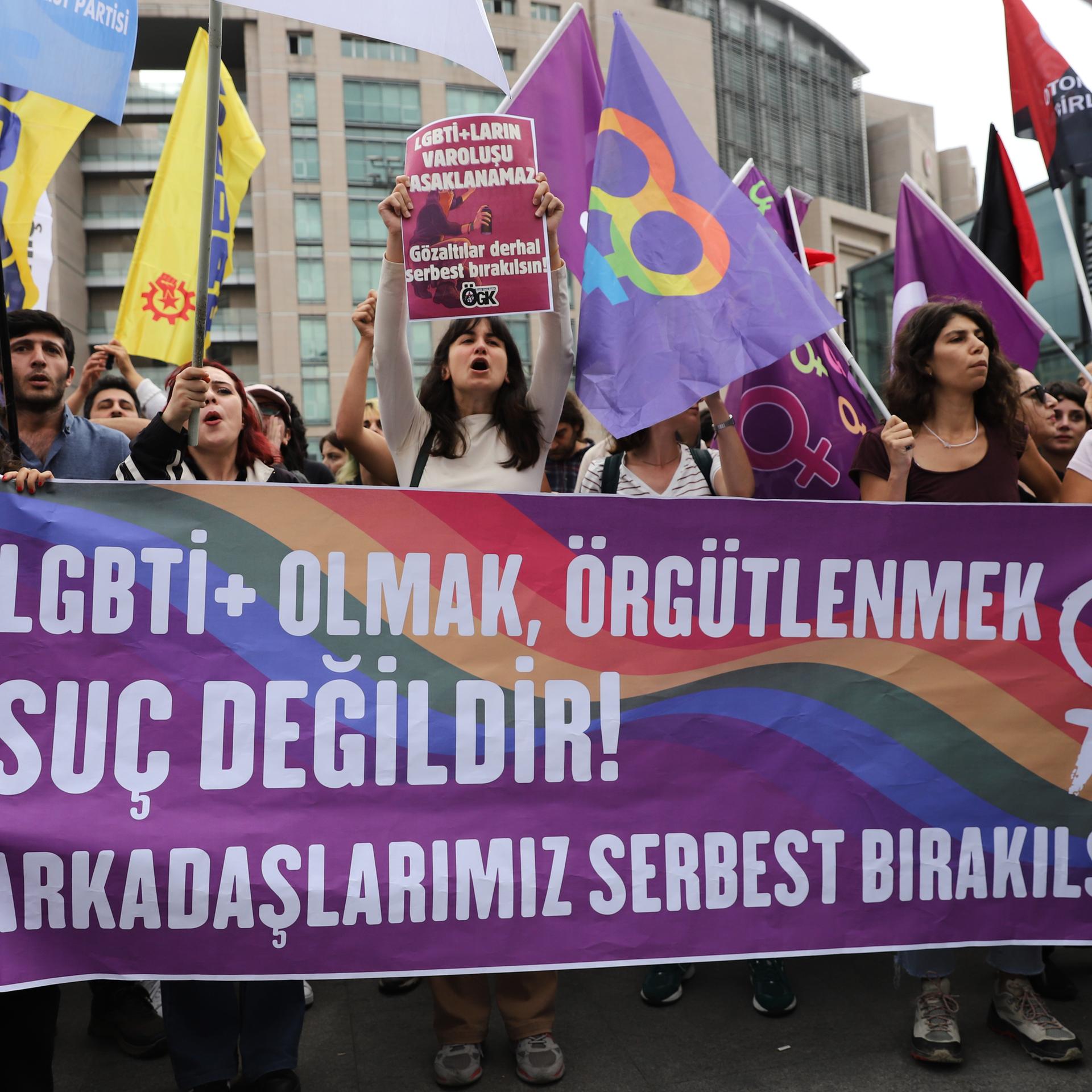 Türkei, Istanbul: Unterstützer der LGBTQ+-Rechte halten Banner und Fahnen vor dem Gerichtsgebäude Çaglayan. 