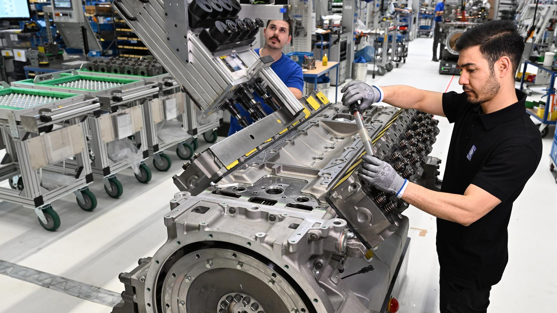 Mitarbeiter von Rolls Royce Power Systems bauen in ihrem Werk Motoren zusammen. 