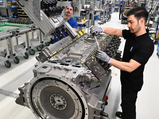 Mitarbeiter von Rolls Royce Power Systems bauen in ihrem Werk Motoren zusammen. 