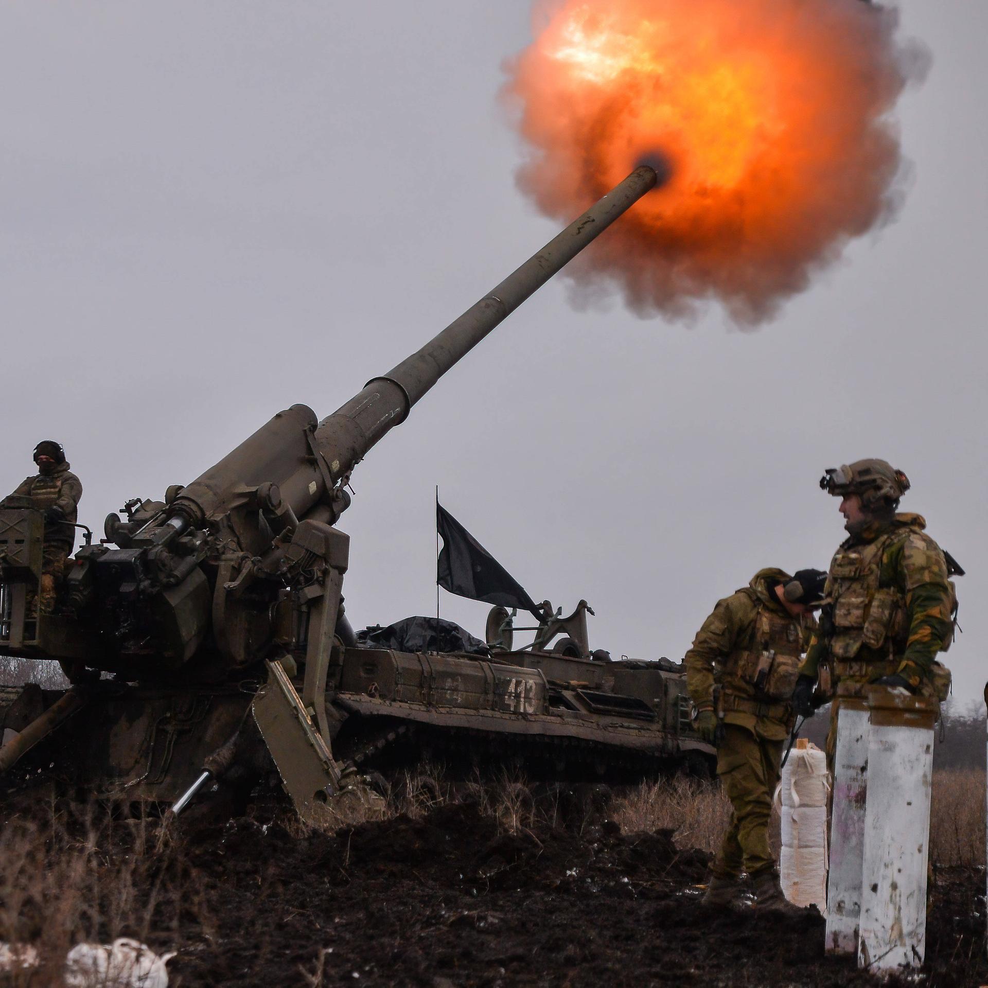 Ukrainische Soldaten feuern ein Artilleriegeschoss ab, aus dem ein Feuerball entsteht.