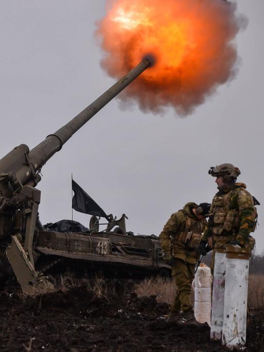 Ukrainische Soldaten feuern ein Artilleriegeschoss ab, aus dem ein Feuerball entsteht.