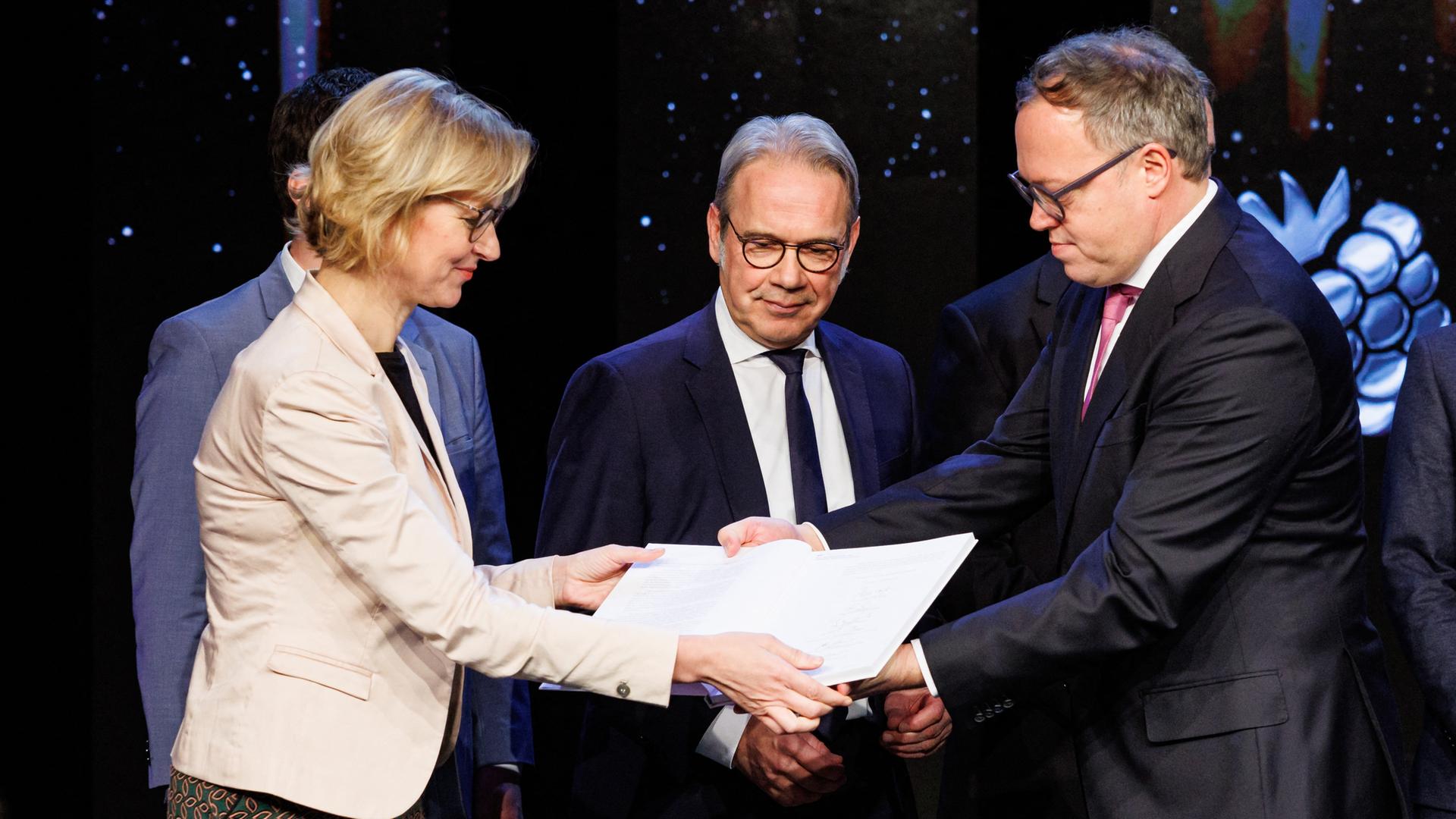 Katja Wolf (BSW), Georg Maier (SPD) und Mario Voigt (CDU) halten alle drei den Koalitionsvertrag fest.