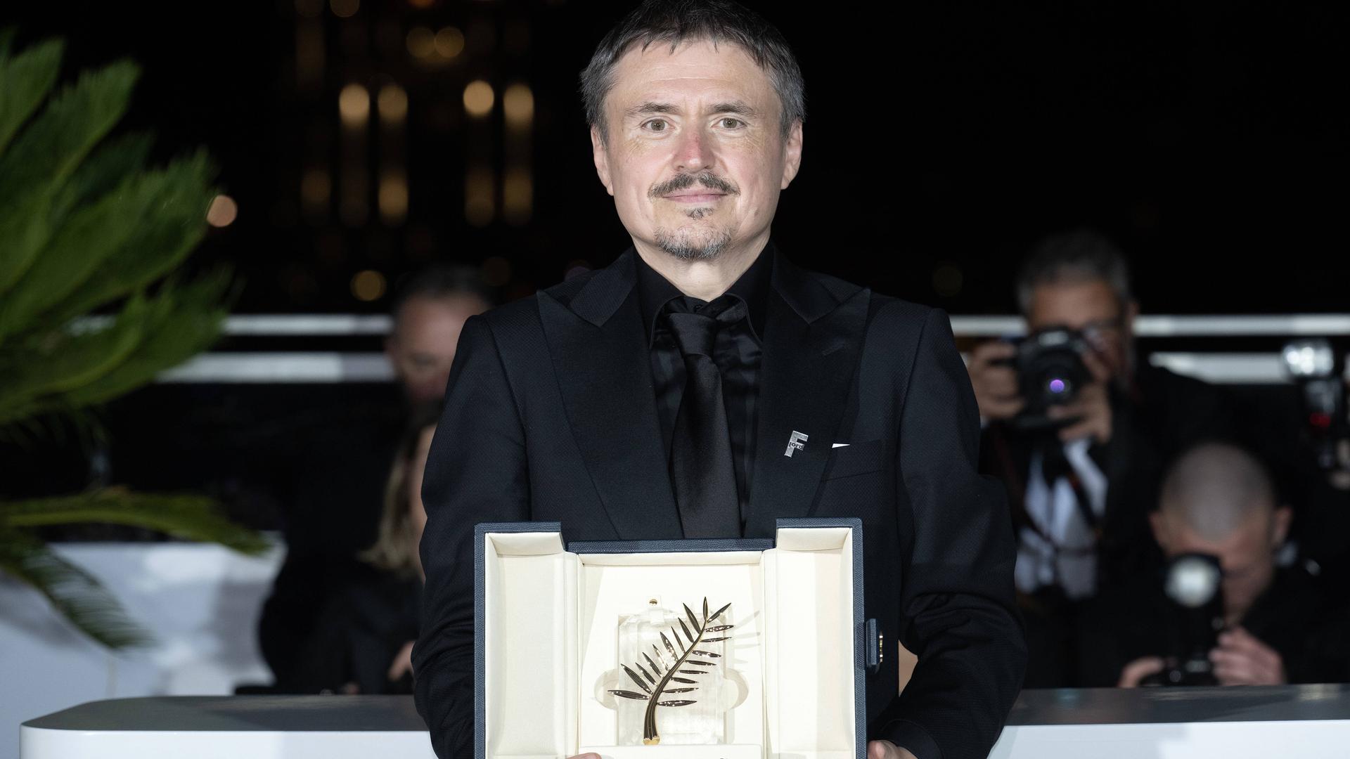 Der rumänische Regisseurs Cristian Mungiu posiert mit der Goldenen Palme 