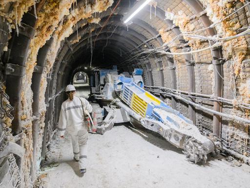 Eine Mitarbeiterin läuft an einem Fräskopf im Atommülllager Asse im Landkreis Wolfenbüttel entlang.