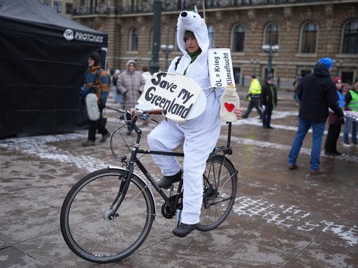 Eine Teilnehmerin in einem Eisbären-Kostüm auf einem Fahrrad hält ein Schild mit der Aufschrift "Save my Greenland" während des bundesweiten Klimastreiks von Fridays for Future.