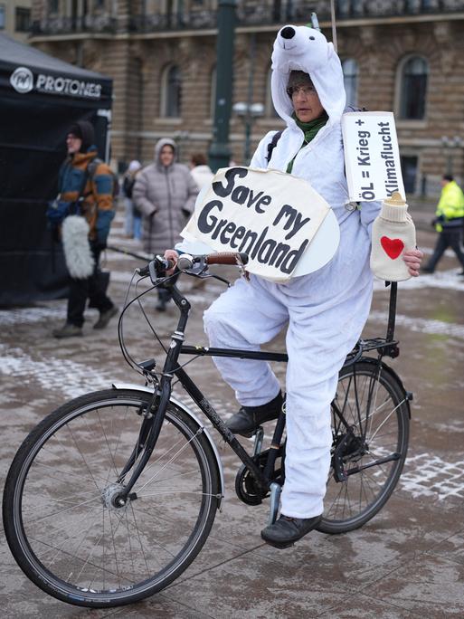 Eine Teilnehmerin in einem Eisbären-Kostüm auf einem Fahrrad hält ein Schild mit der Aufschrift "Save my Greenland" während des bundesweiten Klimastreiks von Fridays for Future.