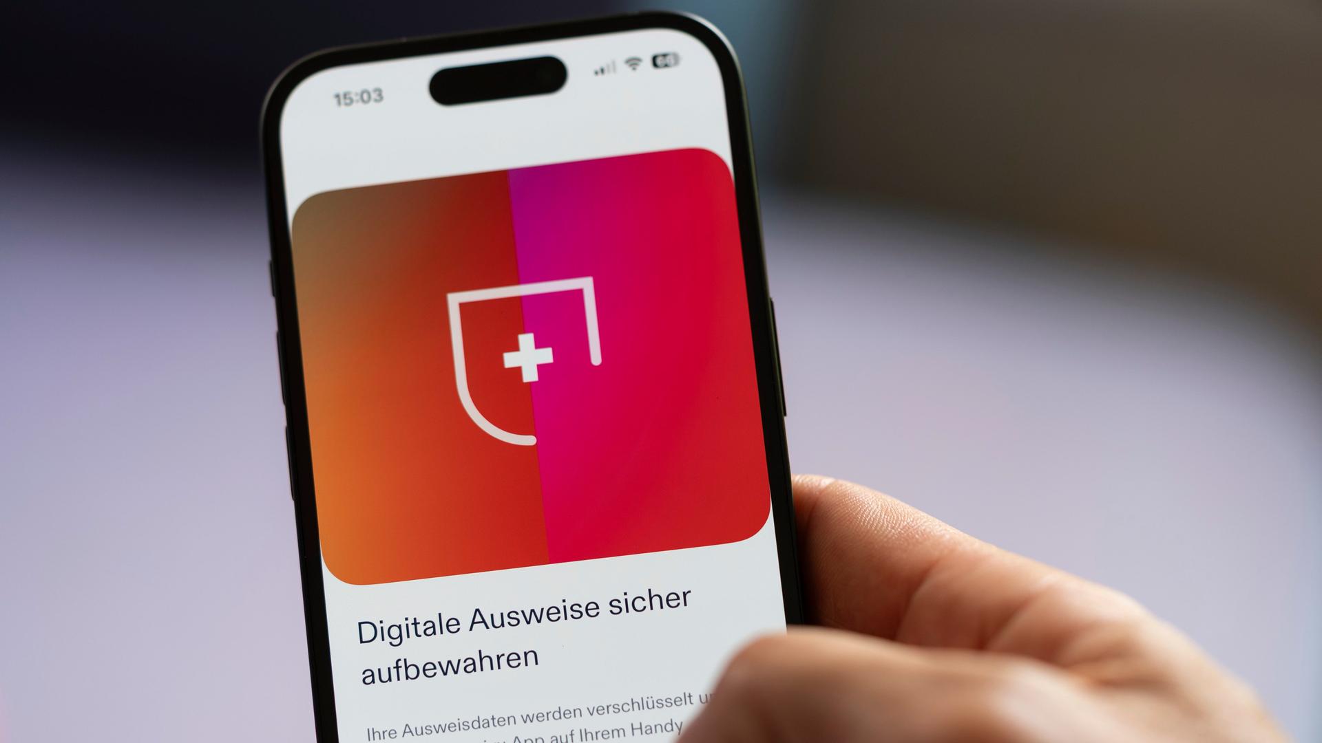 Die für den Nachweis benötigte App 'swiyu' wird auf einem Smartphone angezeigt, das von einer Hand gehalten wird.