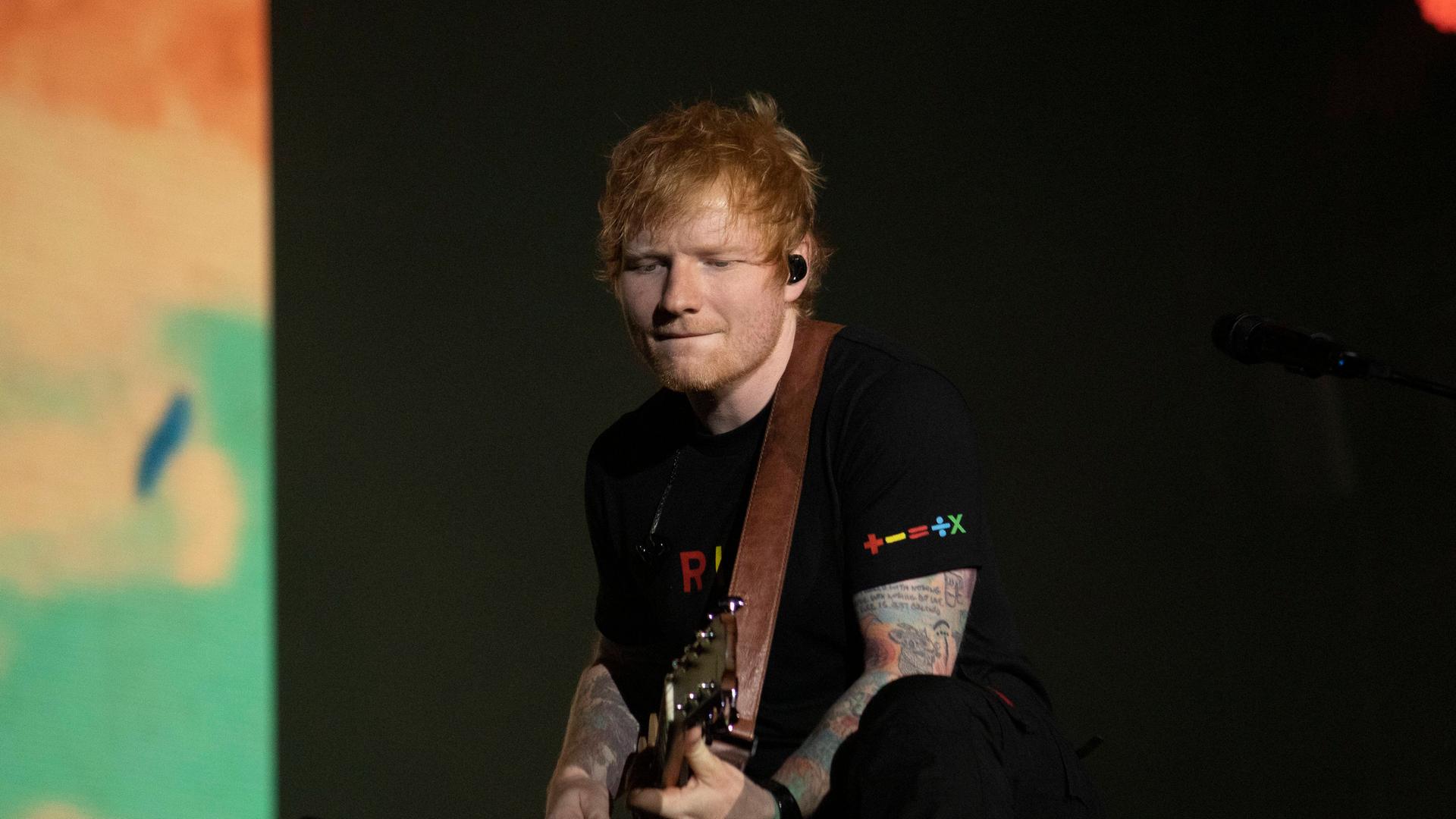Der britische Sänger Ed Sheeran spielt Gitarre auf einer Bühne