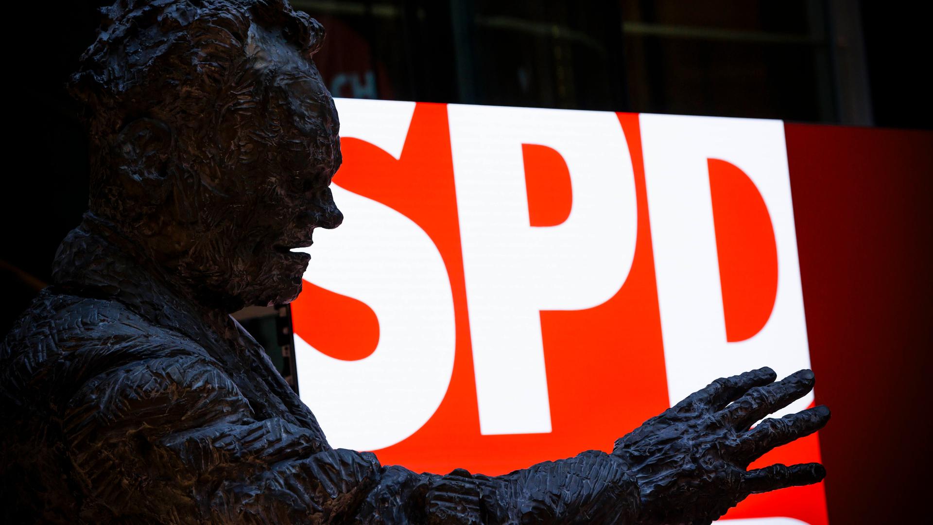 Eine Statue von Willy Brandt steht im Willy-Brandt-Haus vor einem Screen mit dem Schriftzug der SPD in der SPD-Parteizentrale in Berlin