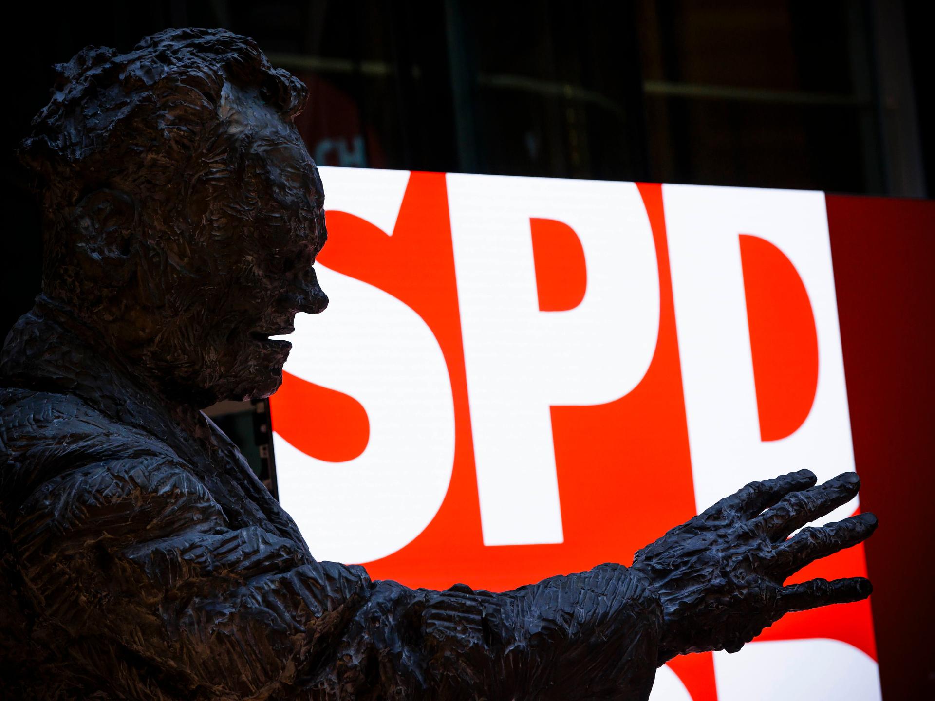 Eine Statue von Willy Brandt steht im Willy-Brandt-Haus vor einem Screen mit dem Schriftzug der SPD in der SPD-Parteizentrale in Berlin
