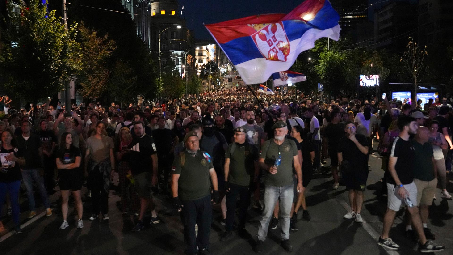 Regierungskritische Demonstranten marschieren abends während einer Demonstration in der Nähe des Büros der Serbischen Fortschrittspartei.