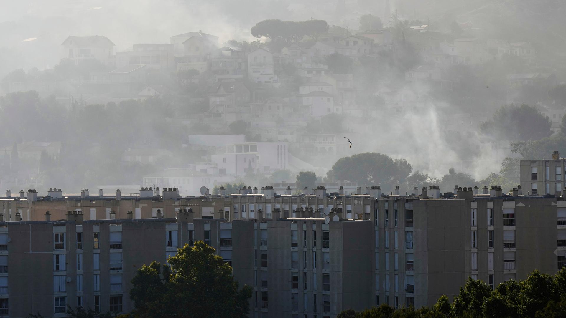 Rauch steigt hinter Gebäuden während eines Waldbrandes im südfranzösischen Marseille auf. Rauch steigt hinter Gebäuden während eines Waldbrandes im südfranzösischen Marseille auf.