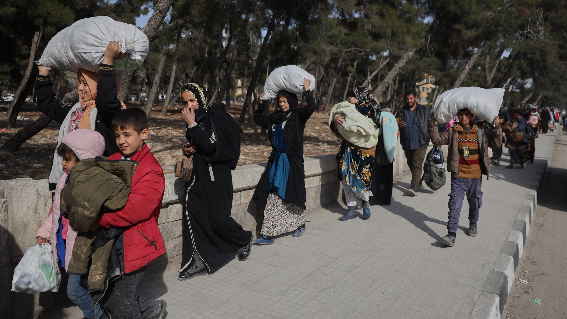 Bewohner fliehen aus Aleppo, sie tragen Säcke und Taschen teils auf den Köpfen. Bewohner fliehen aus Aleppo, sie tragen Säcke und Taschen teils auf den Köpfen.