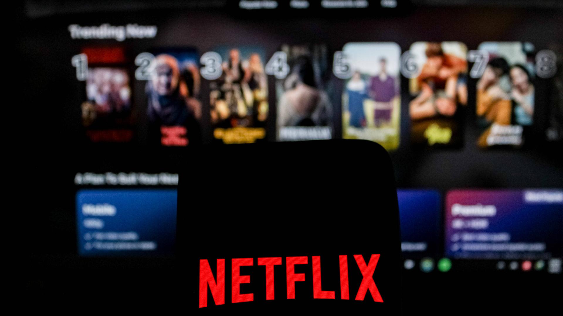 Abgebildet ist das Netflix-Logo in einem Symbolbild der Nachrichtenagentur Imago, im Hintergrund ist das Angebot des US-Streamingdienstes zu sehen.