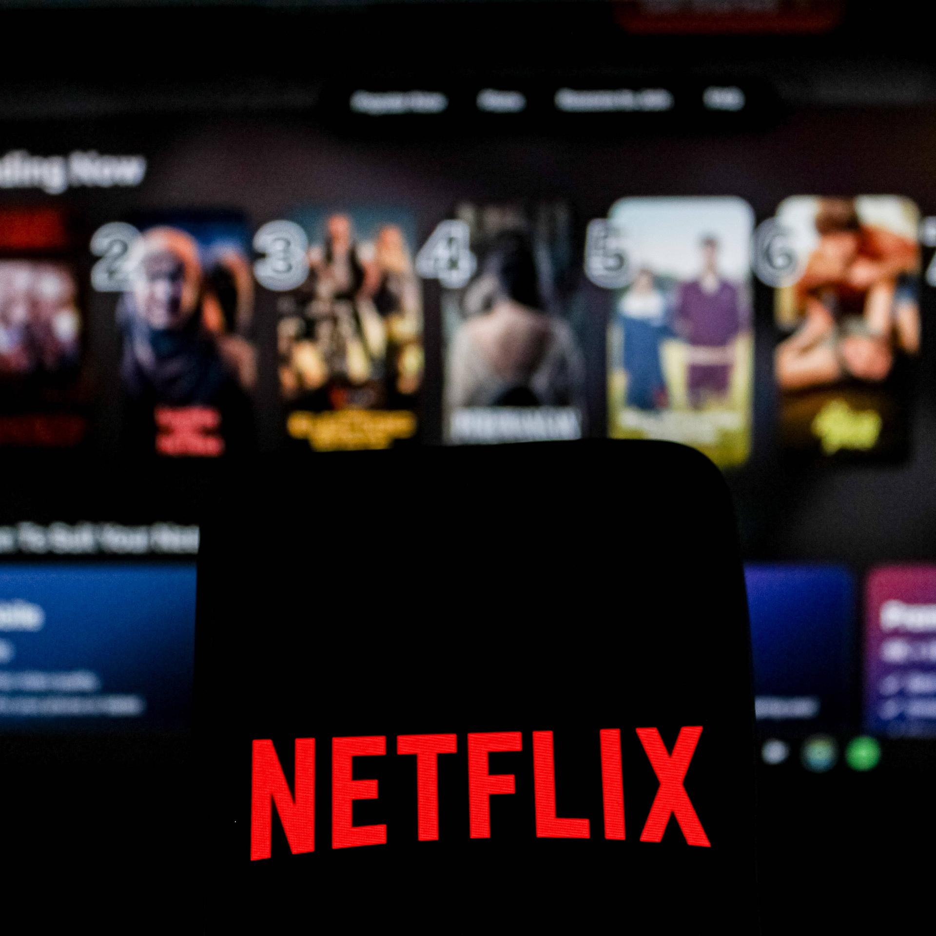 Abgebildet ist das Netflix-Logo in einem Symbolbild der Nachrichtenagentur Imago, im Hintergrund ist das Angebot des US-Streamingdienstes zu sehen.