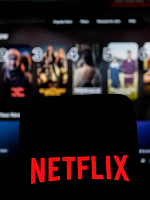 Abgebildet ist das Netflix-Logo in einem Symbolbild der Nachrichtenagentur Imago, im Hintergrund ist das Angebot des US-Streamingdienstes zu sehen.