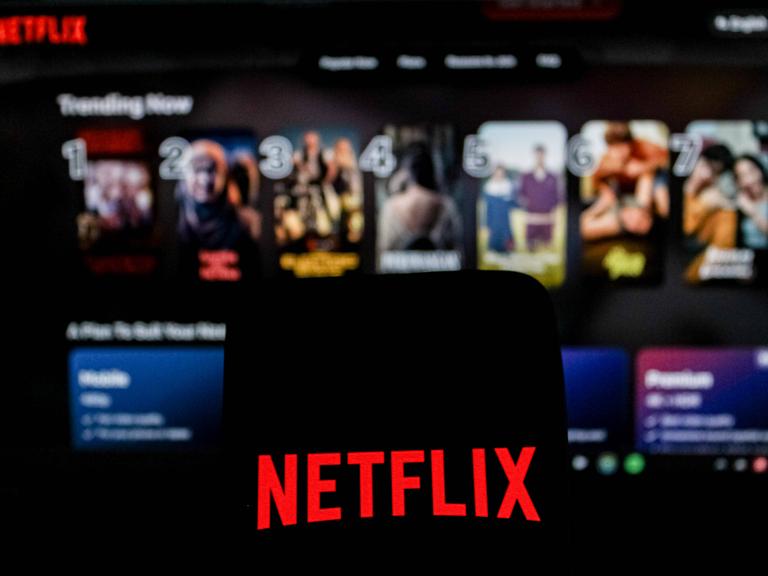 Abgebildet ist das Netflix-Logo in einem Symbolbild der Nachrichtenagentur Imago, im Hintergrund ist das Angebot des US-Streamingdienstes zu sehen.