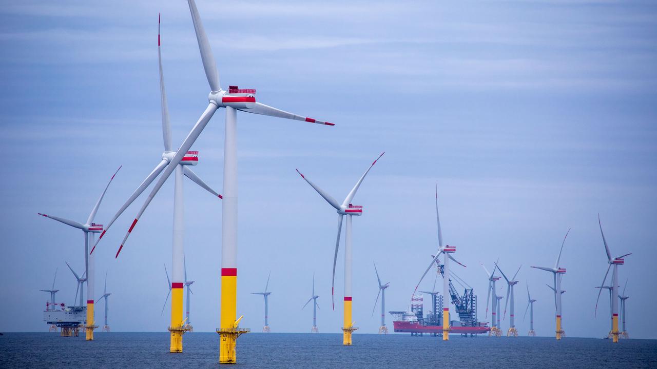 Ein Arbeitsschiff steht auf Stelzen zwischen den Windrädern die in der Ostsee. Im Vordergrund ist der Windpark "Arkona" etwa 35 Kilometer nordöstlich von Rügen zu sehen. Im Hintergrund die Offshore-Windkraftanlagen des Ostsee-Windpark "Wikinger"