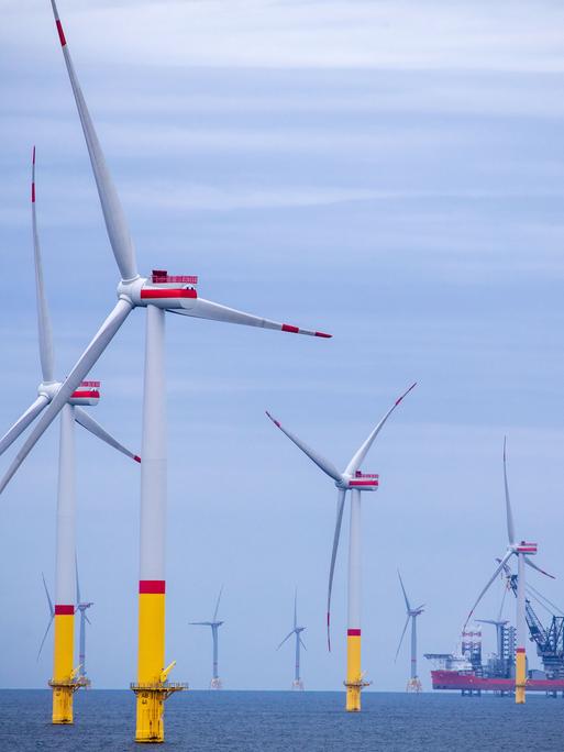 Ein Arbeitsschiff steht auf Stelzen zwischen den Windrädern die in der Ostsee. Im Vordergrund ist der Windpark "Arkona" etwa 35 Kilometer nordöstlich von Rügen zu sehen. Im Hintergrund die Offshore-Windkraftanlagen des Ostsee-Windpark "Wikinger"