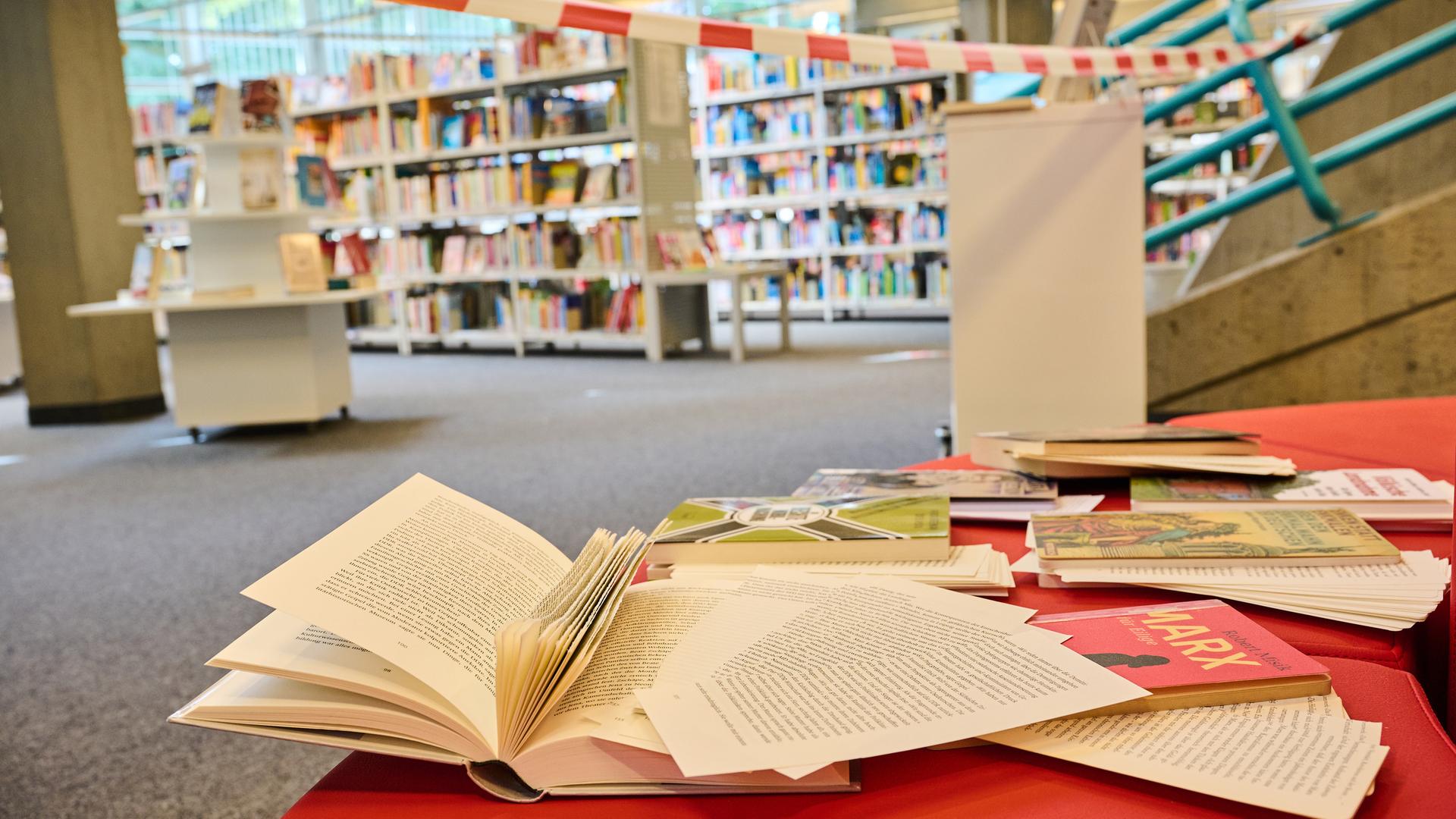 In einer Bibliothek im Berliner Bezirk Tempelhof-Schöneberg liegen Bücher mit herausgeschnittenen Seiten auf der Lesebank. Die Bibliothek sieht sich von Rechten angegriffen.