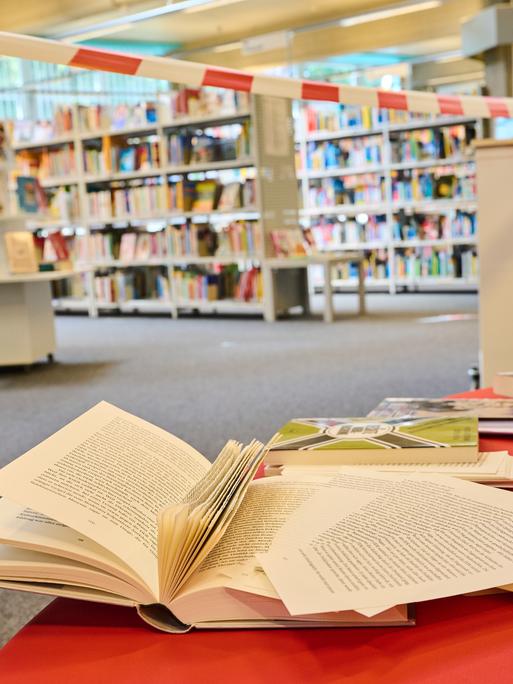 In einer Bibliothek im Berliner Bezirk Tempelhof-Schöneberg liegen Bücher mit herausgeschnittenen Seiten auf der Lesebank. Die Bibliothek sieht sich von Rechten angegriffen.