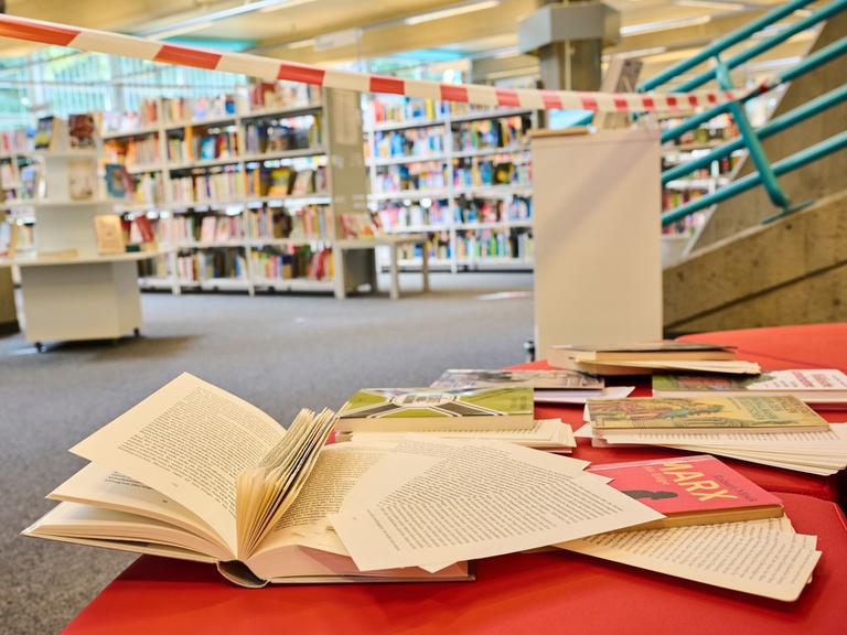 In einer Bibliothek im Berliner Bezirk Tempelhof-Schöneberg liegen Bücher mit herausgeschnittenen Seiten auf der Lesebank. Die Bibliothek sieht sich von Rechten angegriffen.