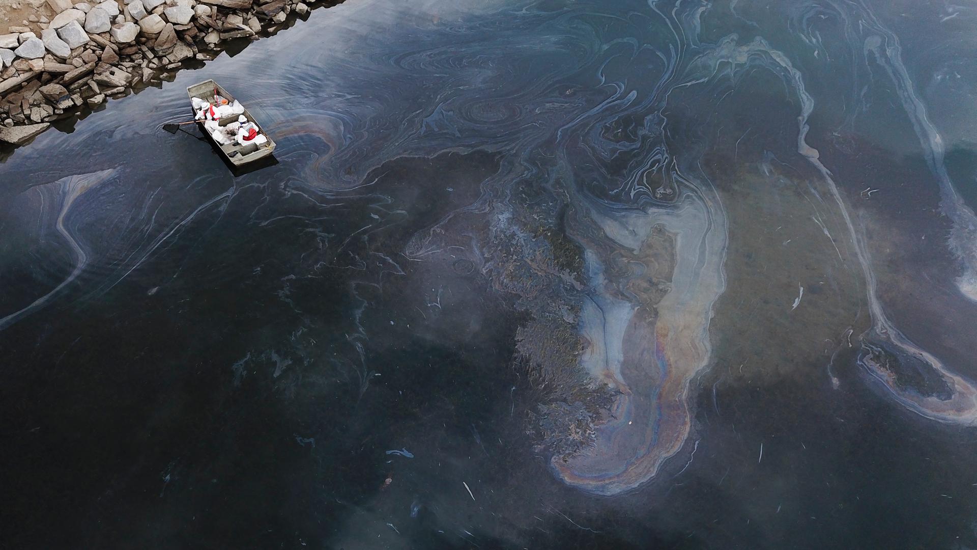 Eine Luftaufnahme vom 4. Oktober 2021 zeigt Umweltschutzteams, die nach einem Ölunfall im Pazifischen Ozean in Huntington Beach, Kalifornien, das Öl beseitigen, das ausgelaufen ist und einen Schimmer auf dem Wasser verursacht hat.