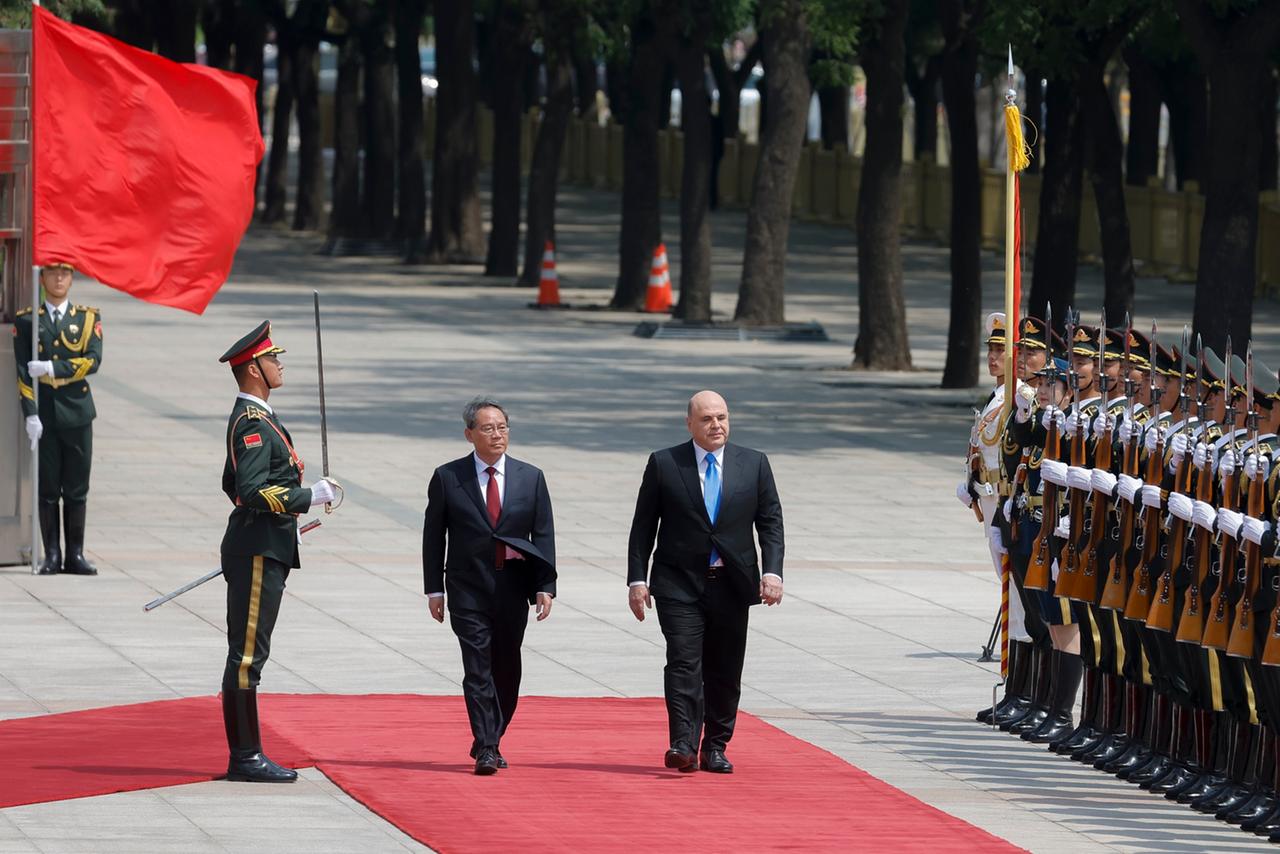 China, Peking: Michail Mischustin (M, r), Ministerpräsident von Russland, und Li Qiang, Ministerpräsident von China, nehmen an einer Begrüßungszeremonie teil. 