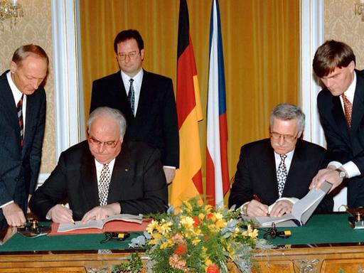 Bundeskanzler Helmut Kohl (l) und der tschechische Ministerpräsident Vaclav Klaus sitzen an einem Tisch und unterzeichnen Verträge  