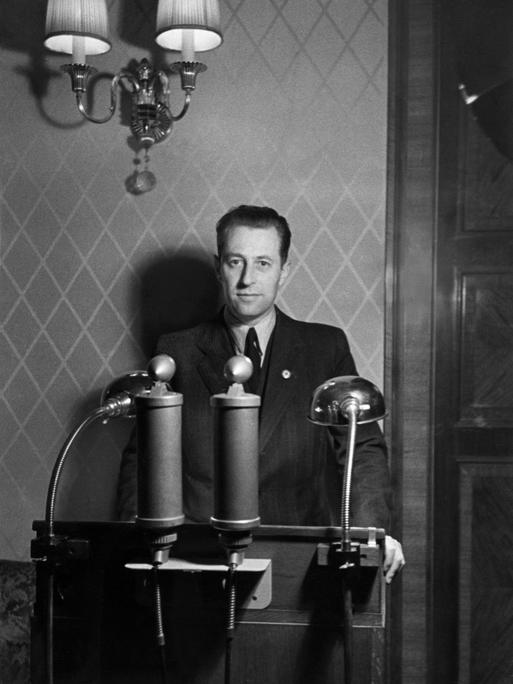 Hans Fritzsche steht am Mikrofon 1941. Er war Mitglied der NSDAP und arbeitete im Propagandaministerium und war für das tägliche Radioprogramm zuständig.