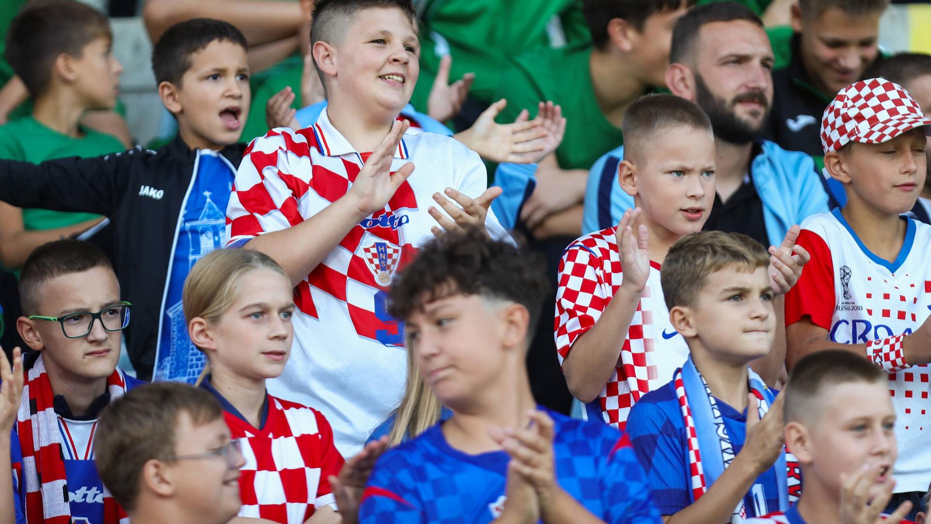 Kinder mit kroatischen Trikots und Schals auf der Tribüne.