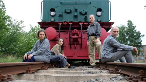 Elisabeth Müller (l-r), Sophia Hahn, Margarita Wiesner und Andreas Ühlein, Schauspieler des Theaters "Das letzte Kleinod" sitzen in Ferropolis auf ausgedienten Gleisen vor einer Lokomotive.