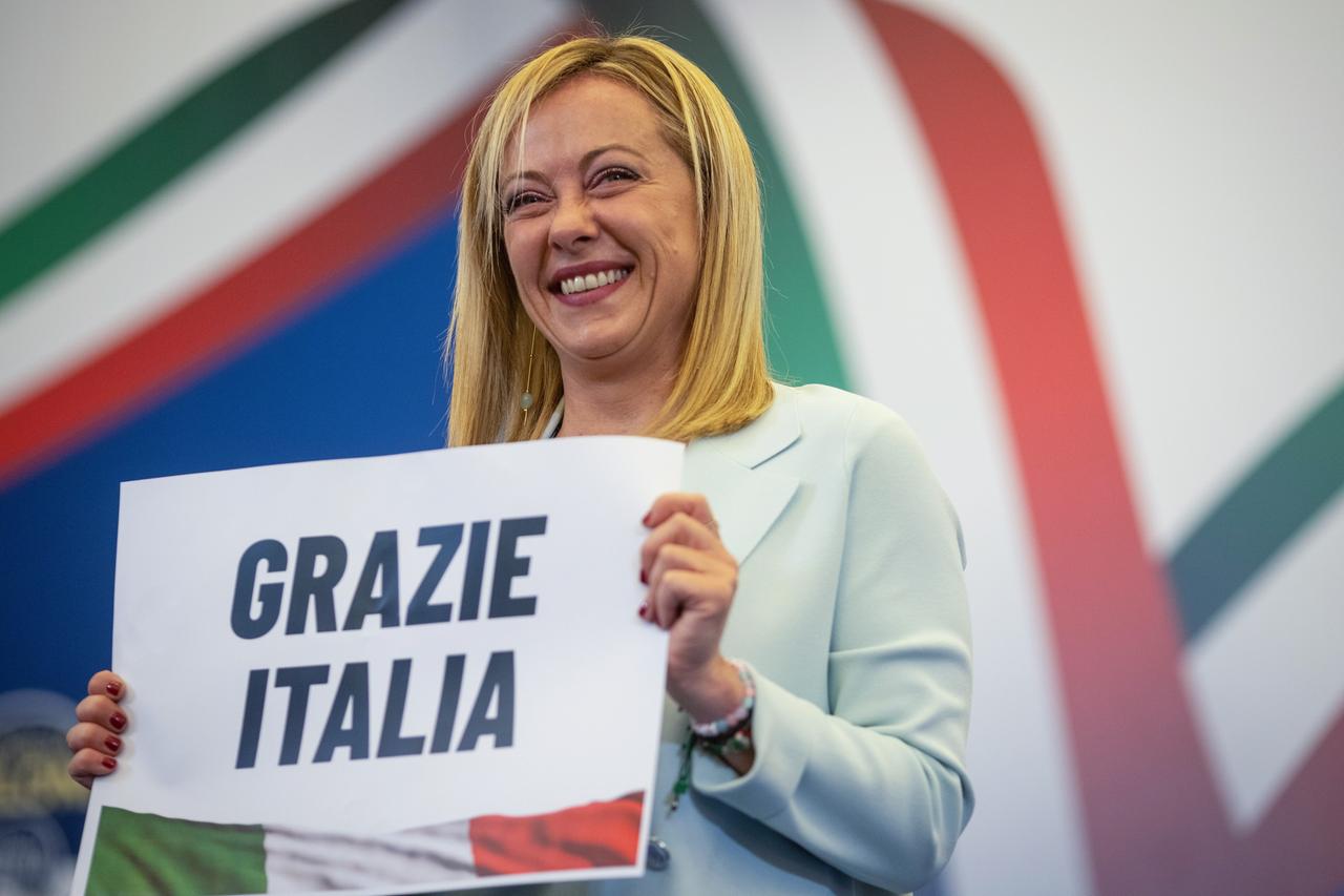 Giorgia Meloni hält ein Plakat in den Händen, auf dem steht "Grazie Italia".