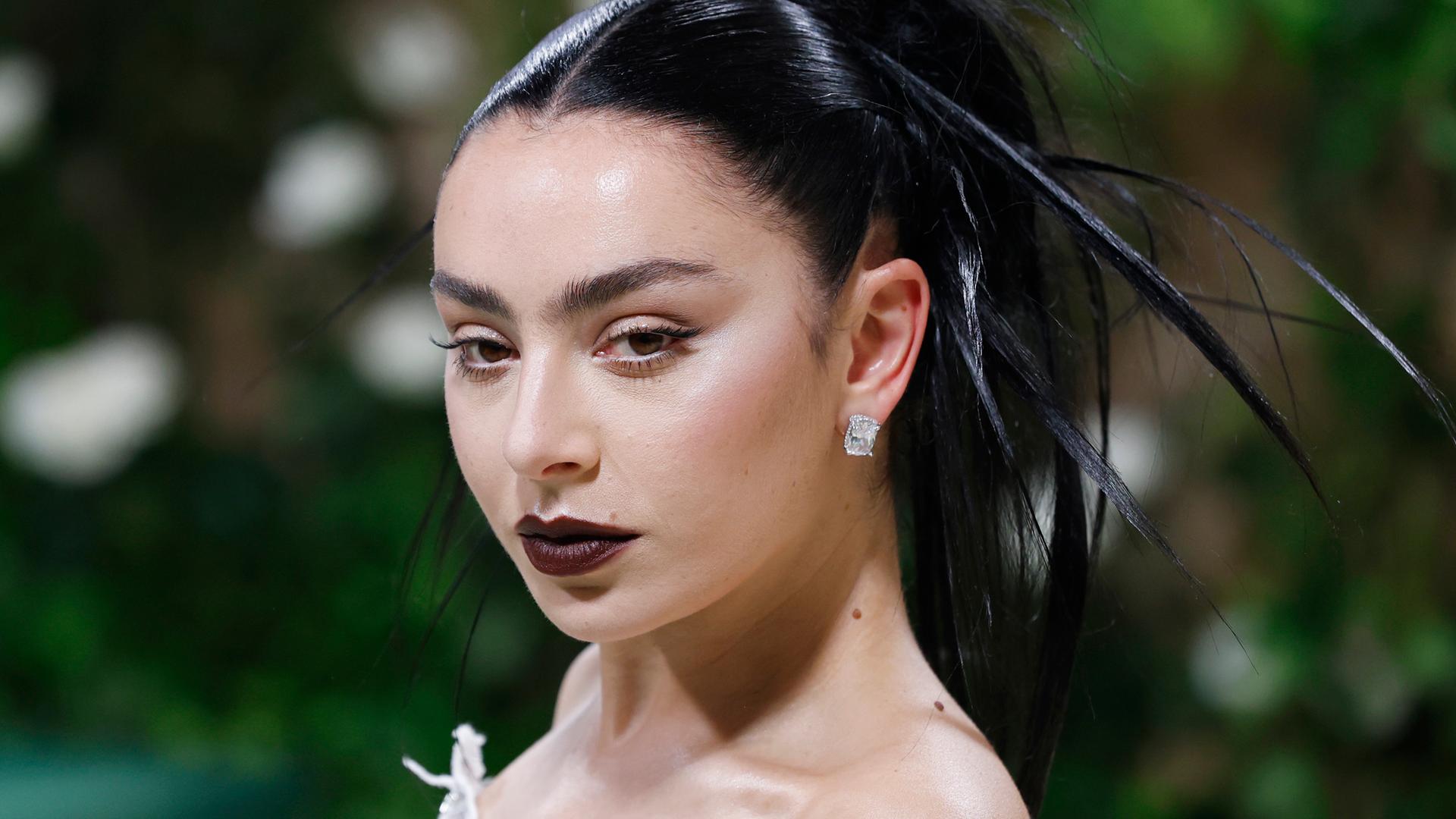 Charli XCX blickt mir frostigem Gesichtsausdruck in die Kamera