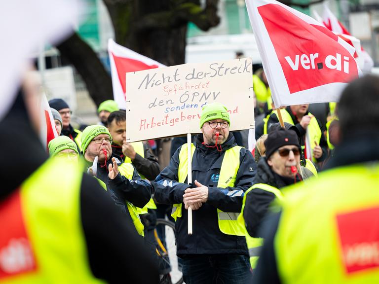 Ein Teilnehmer einer Verdi-Demonstration steht mit einem Schild mit der Aufschrift "Nicht der Streik gefährdet den ÖPNV, sondern der Arbeitgeberverband" während einer Kundgebung in der Innenstadt von Hannover. 