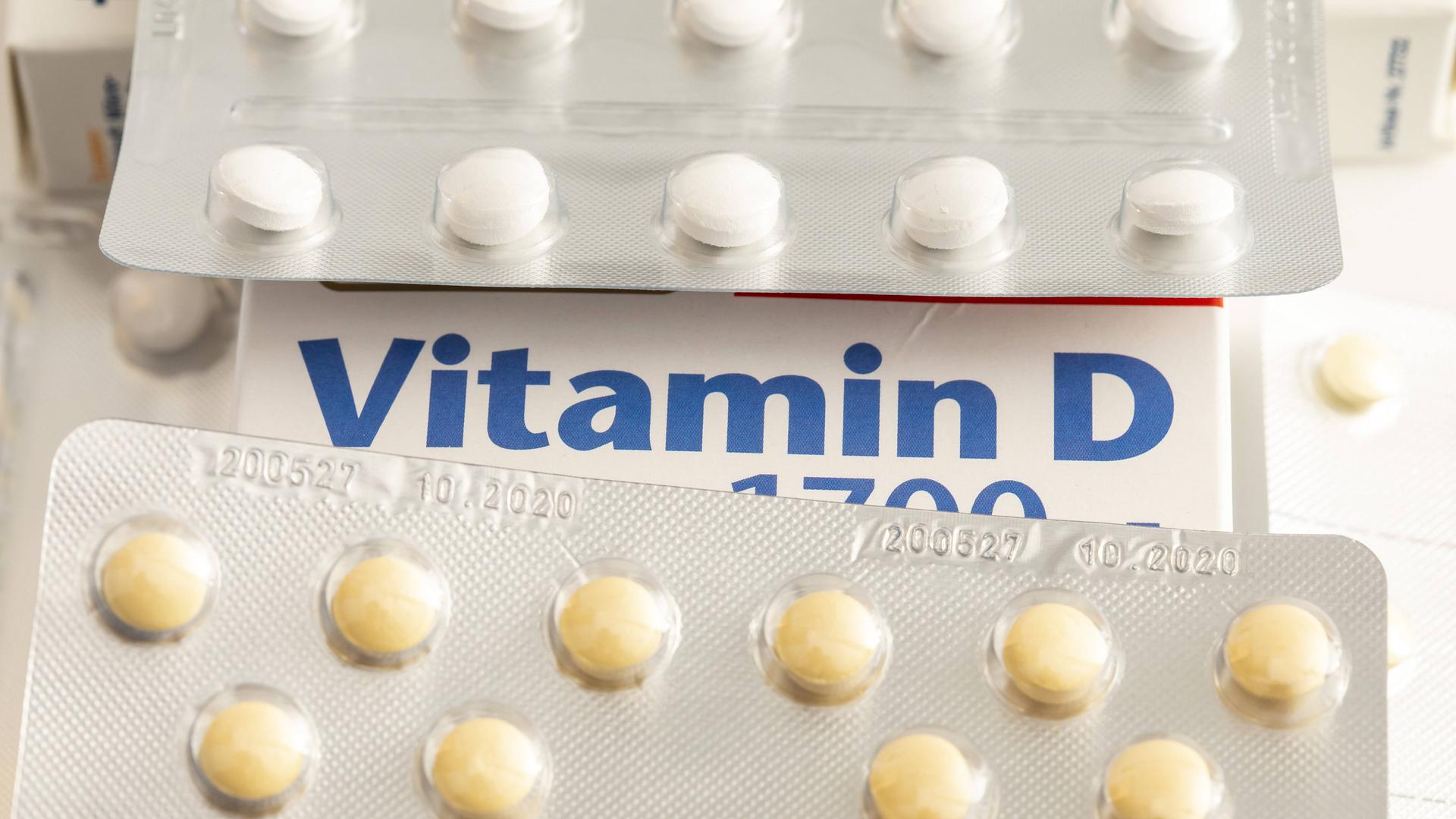 Zwei Streifen Tabletten liegen auf einer Verpackung, auf der steht "Vitamin D".