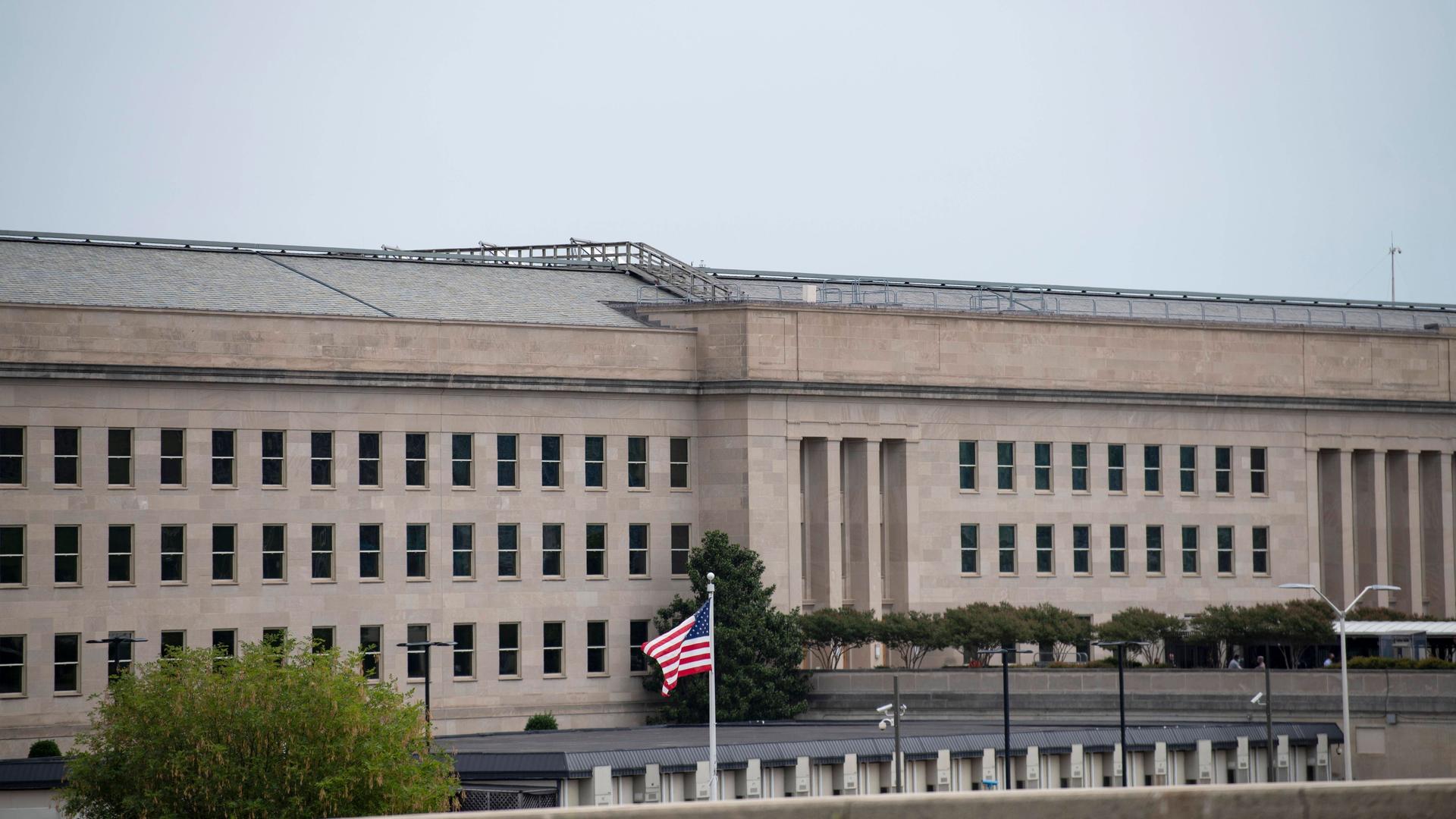 USA, Arlington: Das Gebäude des Pentagon. Davor weht eine amerikanische Flagge.