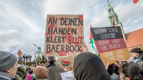 Teilenehmende einer Demonstration gegen den israelische Militäreinsatz im Gaza-Streifen infolge der Terrorangriffe der Hamas halten Plakate hoch.