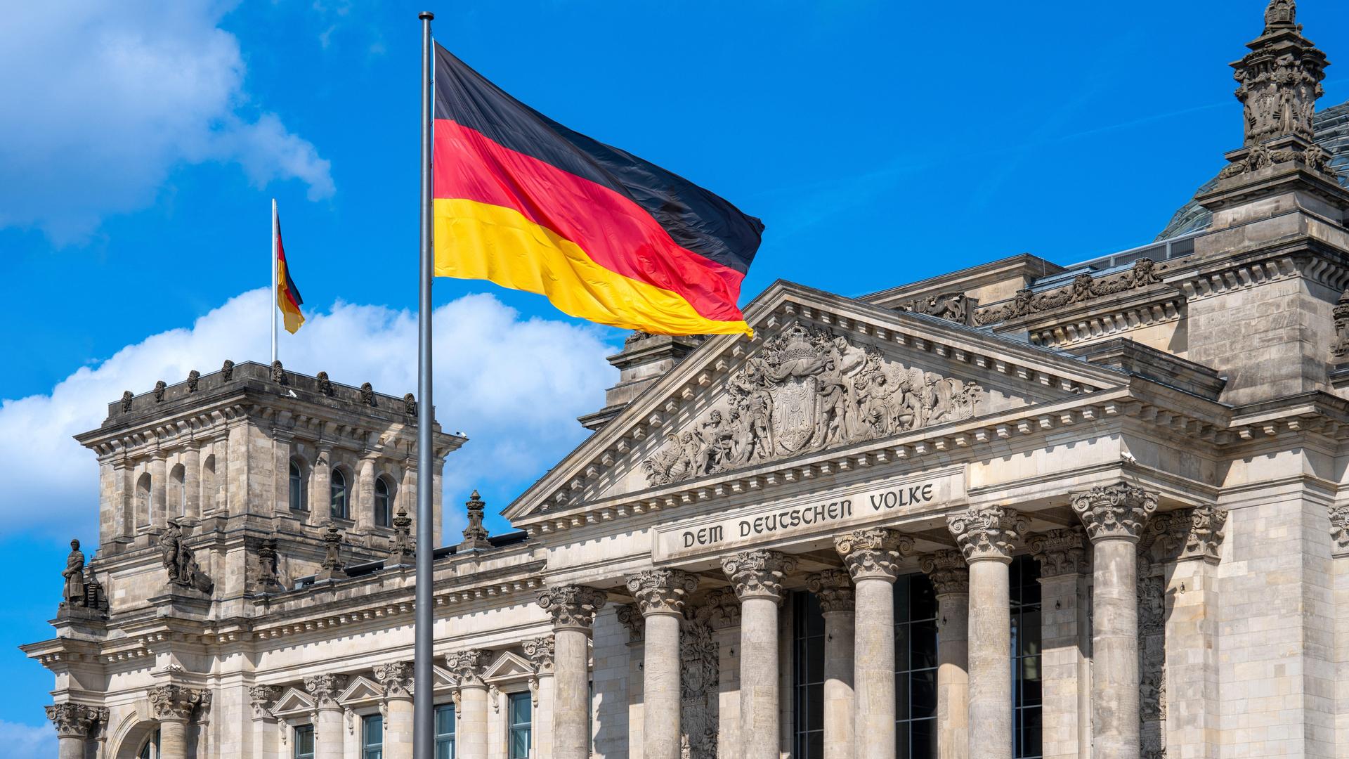 Die deutsche Flagge weht vor dem Reichstag in Berlin.