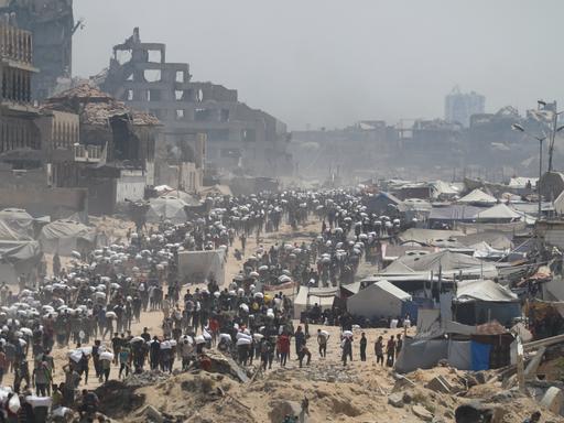 27. Juli 2025, Gaza City: Menschen auf der al-Rashid Straße in West-Jabalia auf dem Weg in den Norden.