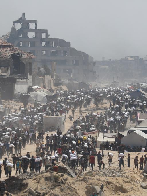 27. Juli 2025, Gaza City: Menschen auf der al-Rashid Straße in West-Jabalia auf dem Weg in den Norden.