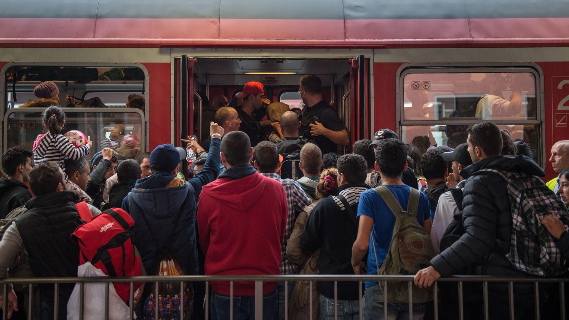 Archivbild: Dutzende Menschen stehen vor einer Regionalzug in Bayern und versuchen, hineinzugelangen.