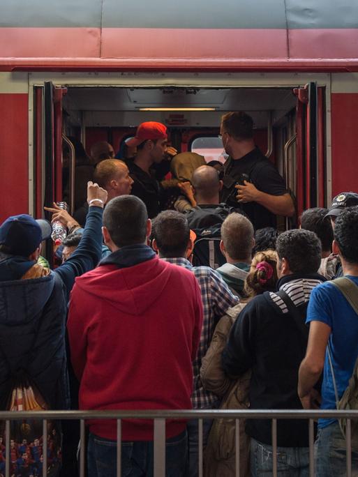 Archivbild: Dutzende Menschen stehen vor einer Regionalzug in Bayern und versuchen, hineinzugelangen.