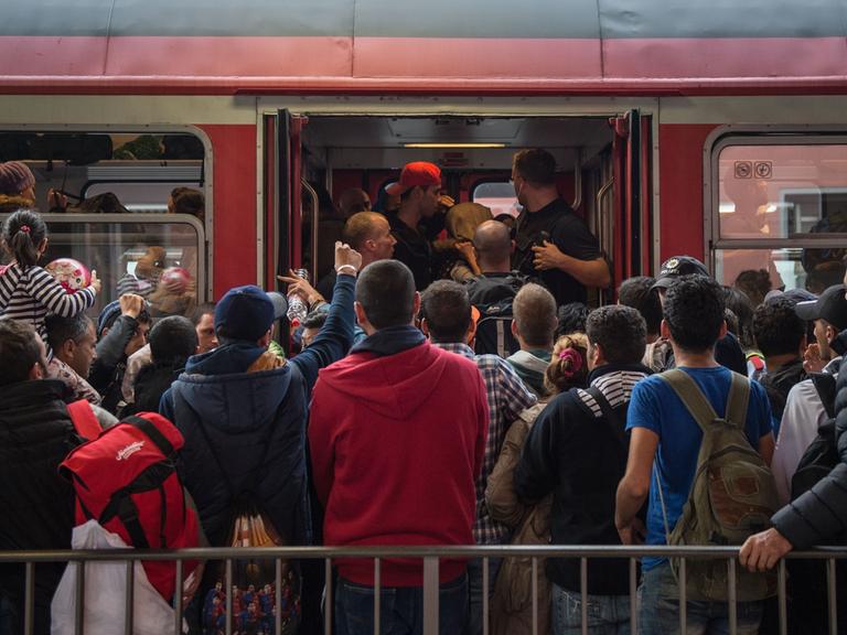 Archivbild: Dutzende Menschen stehen vor einer Regionalzug in Bayern und versuchen, hineinzugelangen.