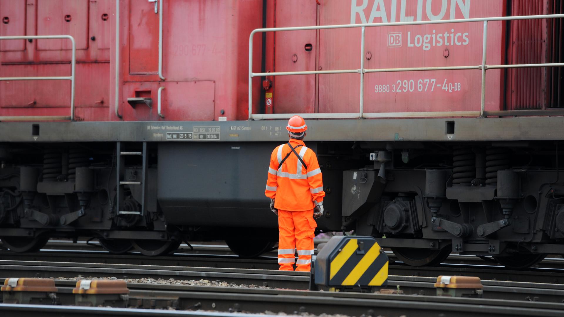 Ein Mitarbeiter der Deutschen Bahn steht am am Rangierbahnhof München vor einer Güterzug Ein Mitarbeiter der Deutschen Bahn steht am am Rangierbahnhof München vor einer Güterzug