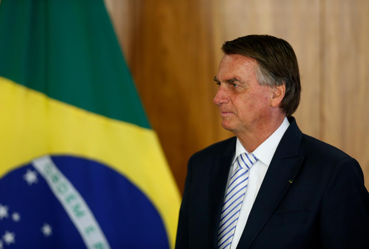 Brasiliens Präsident Jair Bolsonaro neben der brasilianischen Flagge