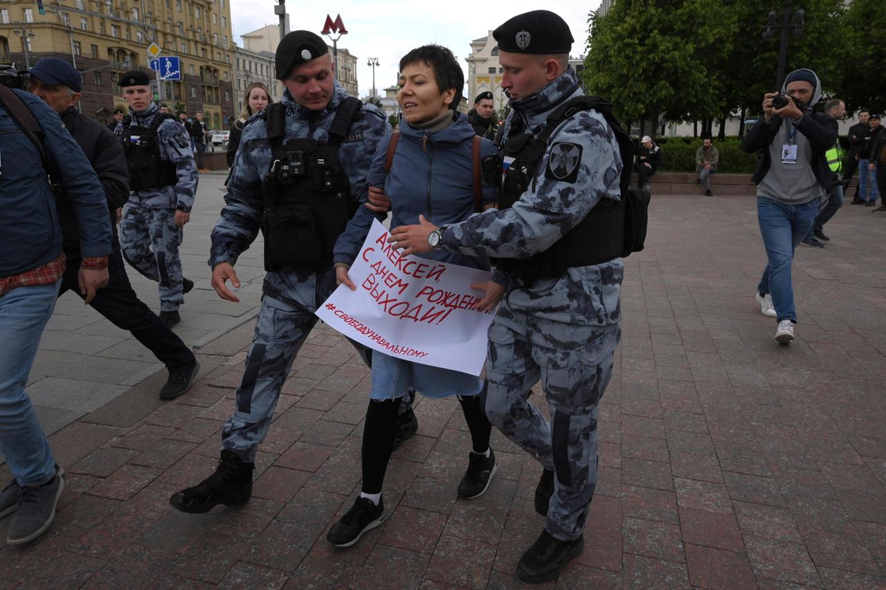 Polizisten führen eine Demonstrantin auf dem Puschkinskaja-Platz ab, die ein Plakat mit der Aufschrift "Happy Birthday Alexej" trägt. 