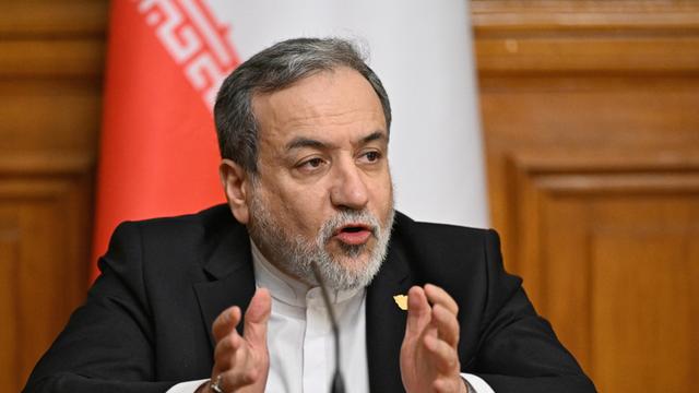Zu sehen ist der iranische Außenministrer Araghchi. Er sitzt an einem Schreibtisch und gestikuliert mit den Händen.